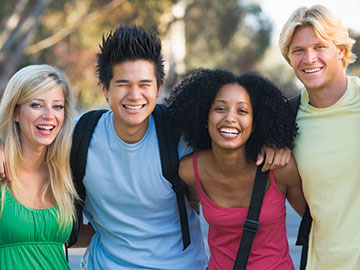 High School or College age students smiling while hanging out at school.