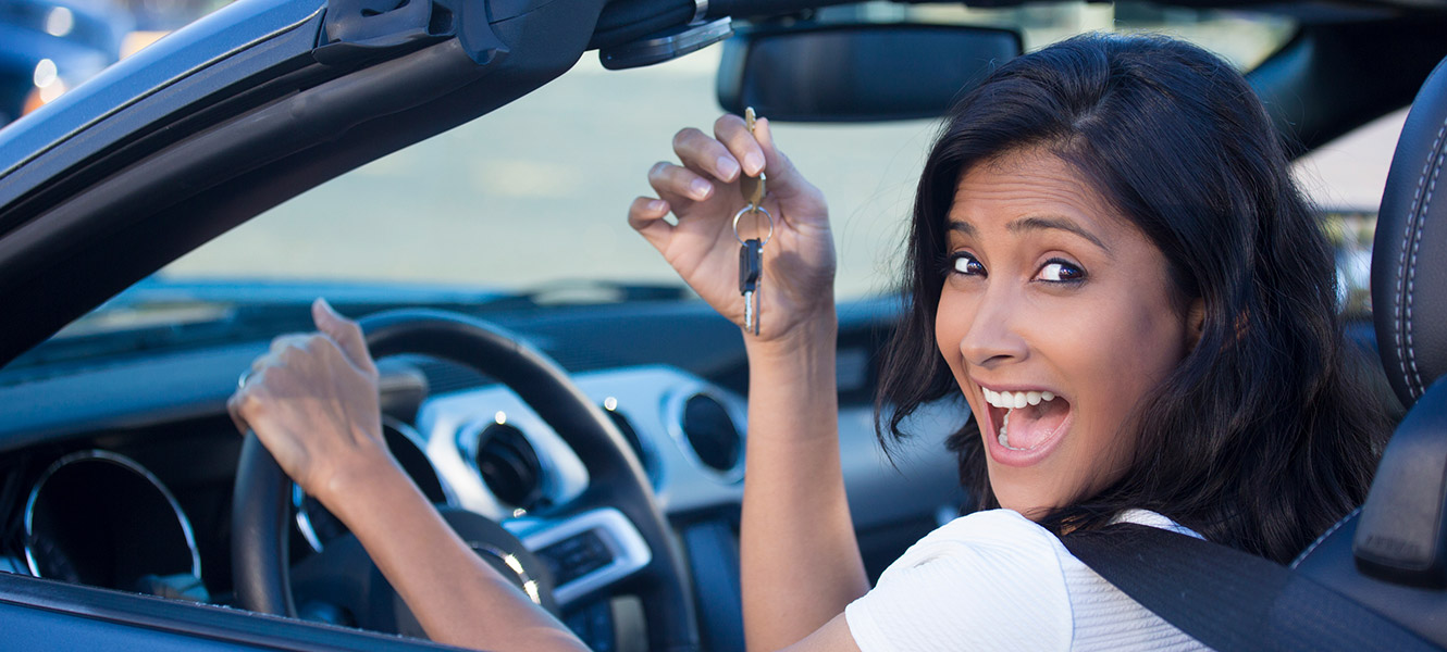 Young woman excited about having keys to a new car