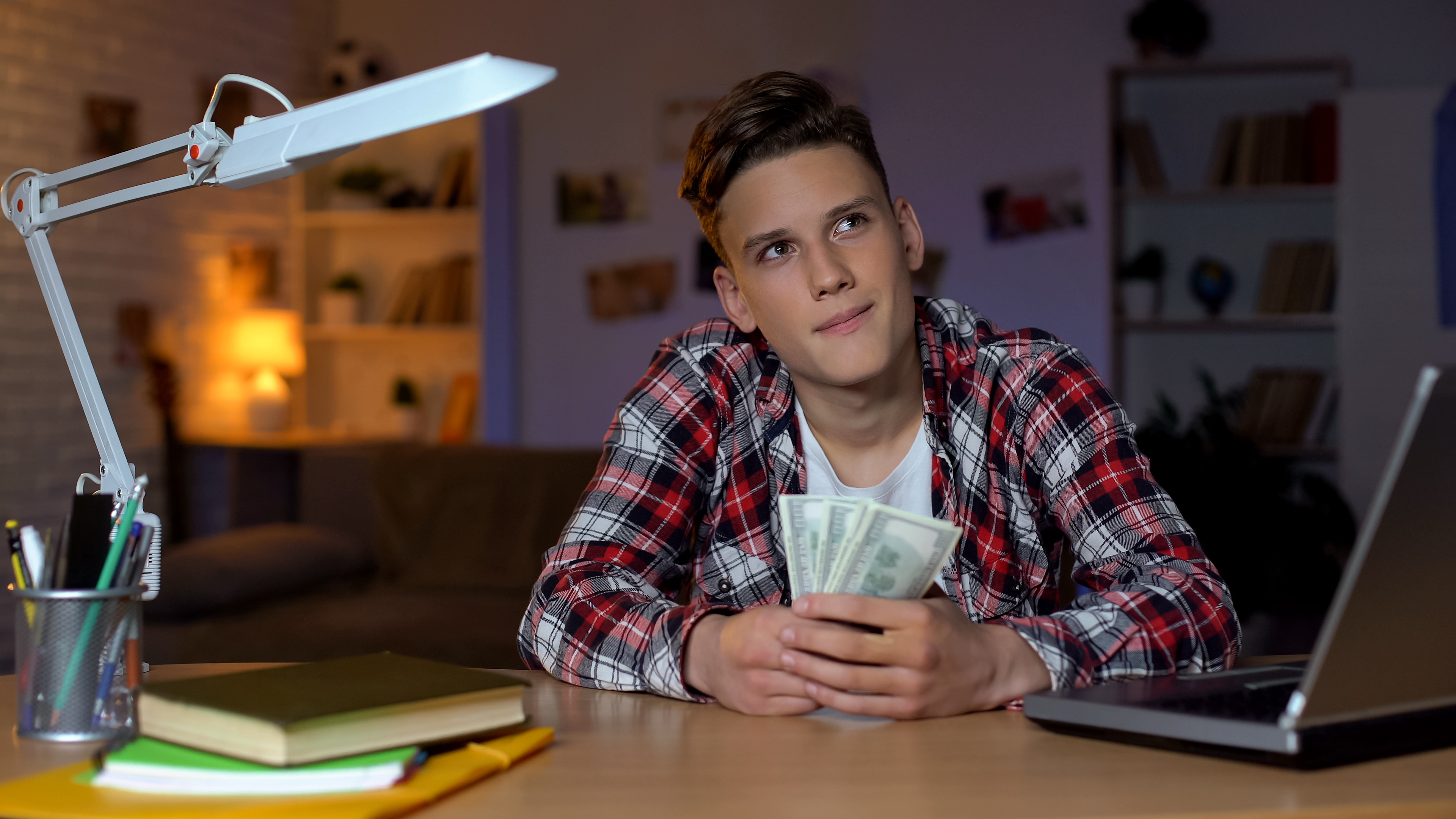 teen boy counting money from first paycheck