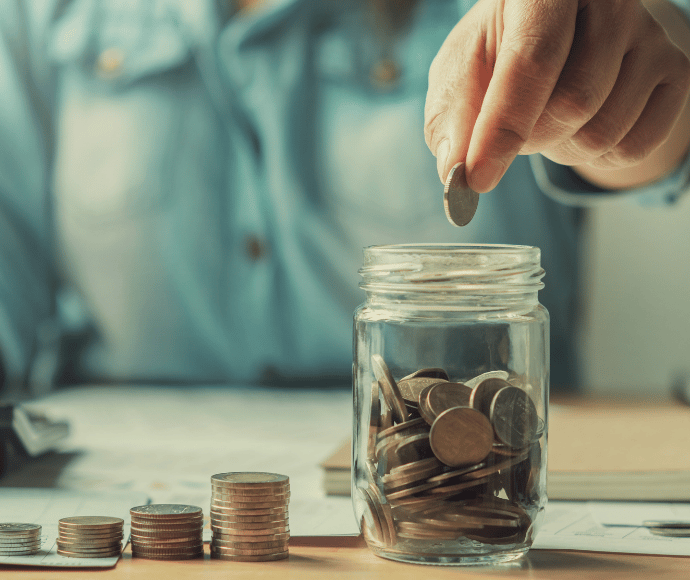 hand dropping coin in jar