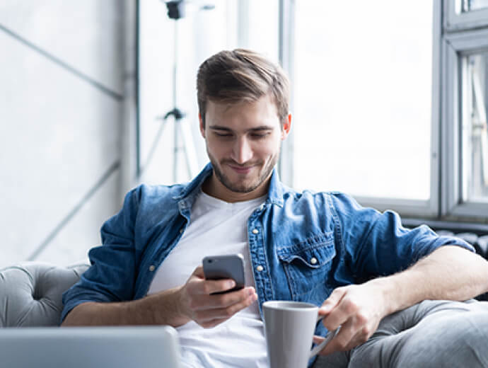 Man with phone and coffee mug