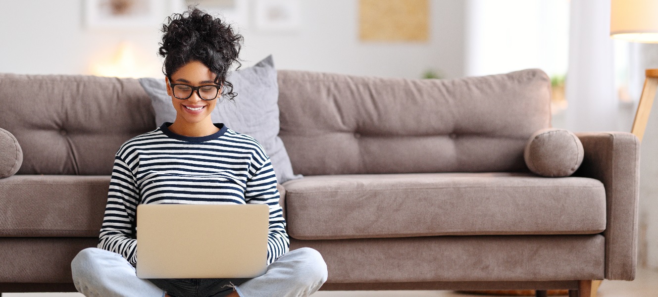 Woman banking from her laptop in comfort of her living room.